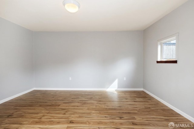 unfurnished room with wood finished floors and baseboards