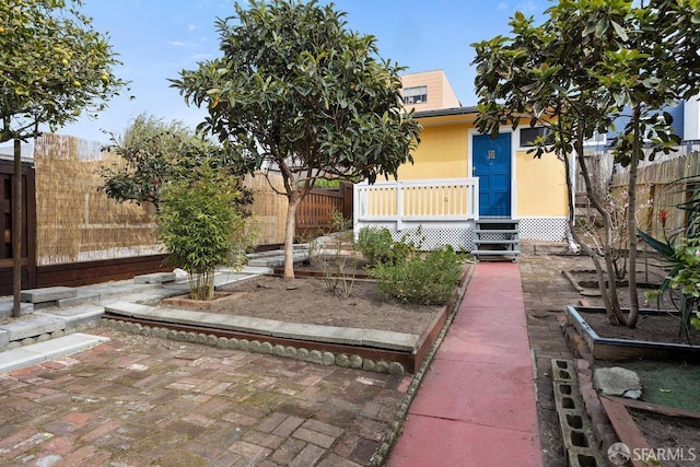 view of front of home featuring a garden and a fenced backyard