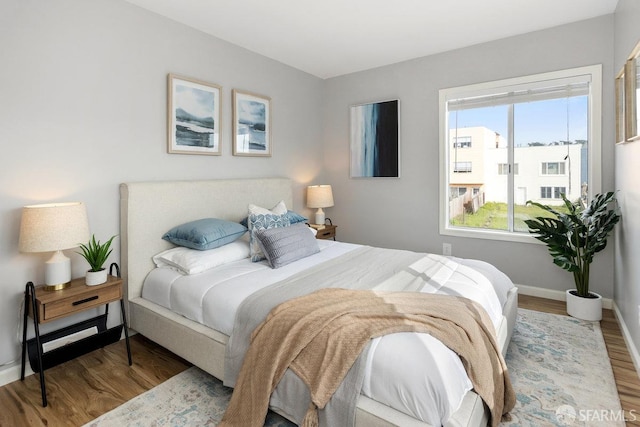 bedroom with wood finished floors and baseboards