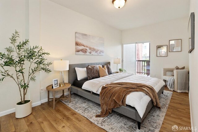 bedroom with light wood-style floors, access to outside, and baseboards