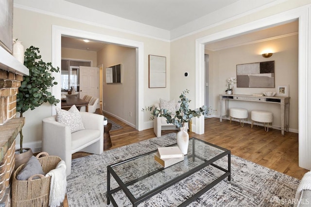 living area featuring baseboards, ornamental molding, and wood finished floors