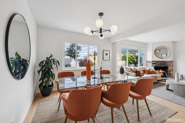 75 Lurline St, San Francisco, CA 94122 - dining area with light wood-style flooring, a fireplace, and a chandelier