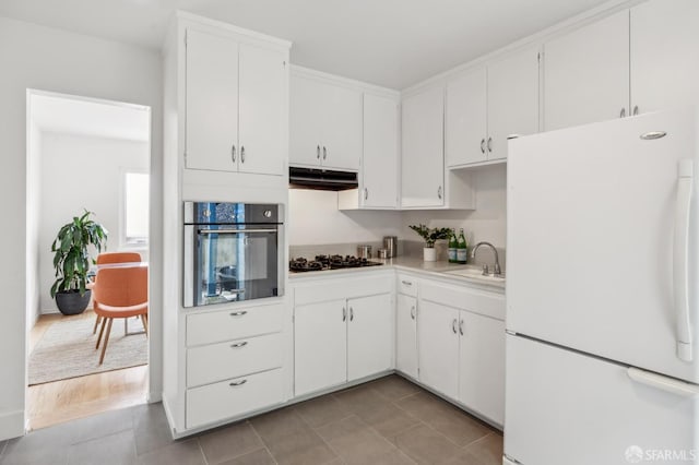 75 Lurline St, San Francisco, CA 94122 - kitchen with freestanding refrigerator, stainless steel oven, under cabinet range hood, a sink, and black gas cooktop