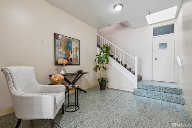 sitting room featuring stairway, a skylight, baseboards, and speckled floor