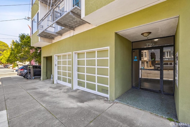 entrance to property featuring stucco siding and an attached garage