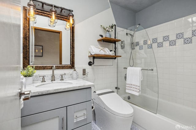 bathroom with toilet, shower / washtub combination, tile walls, wainscoting, and vanity