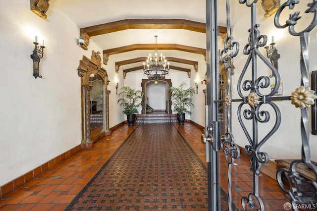 corridor featuring lofted ceiling, baseboards, and an inviting chandelier