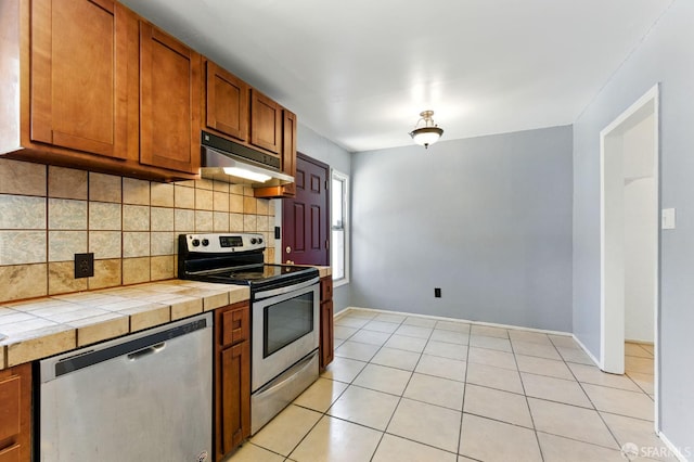 1220 Mesa St, Concord, CA 94518 - kitchen featuring stainless steel appliances, under cabinet range hood, tile counters, backsplash, and brown cabinetry