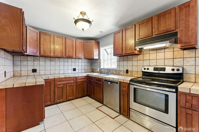1220 Mesa St, Concord, CA 94518 - kitchen featuring stainless steel appliances, under cabinet range hood, tile counters, and light tile patterned floors