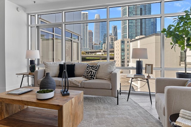 living area with a view of city, floor to ceiling windows, a wealth of natural light, and wood finished floors