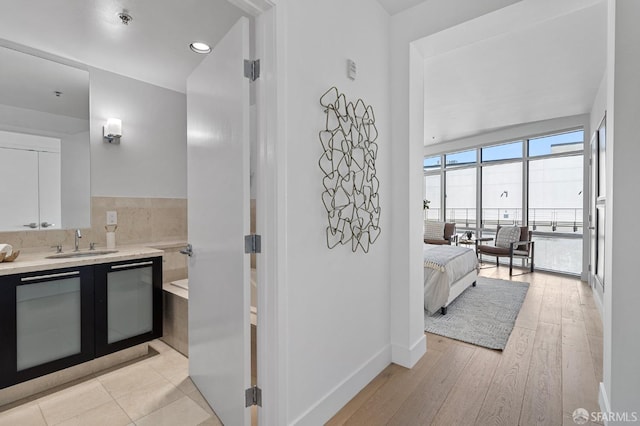 bathroom with vanity, baseboards, and hardwood / wood-style flooring