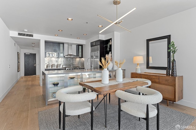 dining area with light wood-style flooring, visible vents, baseboards, and recessed lighting