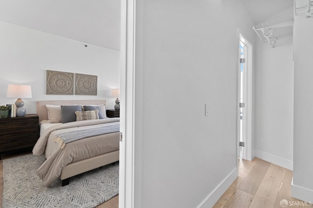 bedroom with baseboards and light wood finished floors