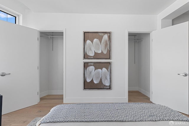 bedroom with a closet, light wood-type flooring, and a walk in closet