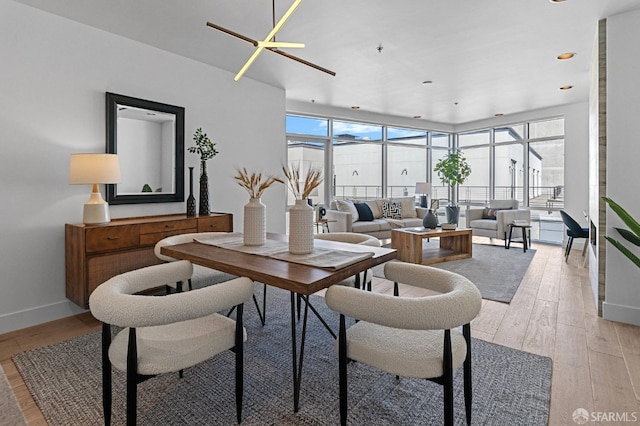 interior space featuring baseboards, recessed lighting, a wealth of natural light, and light wood-style floors