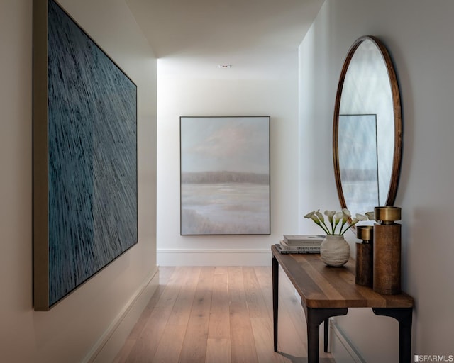 hallway with hardwood / wood-style flooring and baseboards