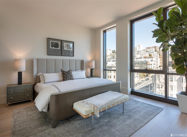 bedroom featuring a view of city and wood finished floors