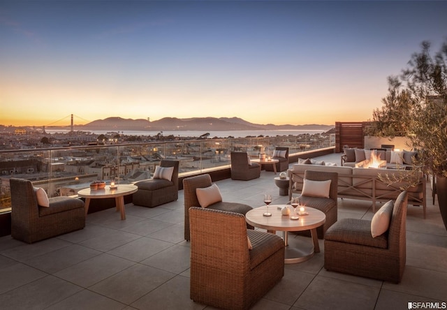 view of patio featuring a mountain view and an outdoor living space with a fire pit