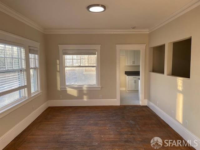 interior space featuring ornamental molding and dark hardwood / wood-style flooring