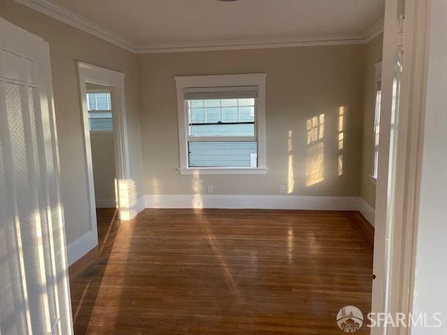 empty room with crown molding and dark hardwood / wood-style floors