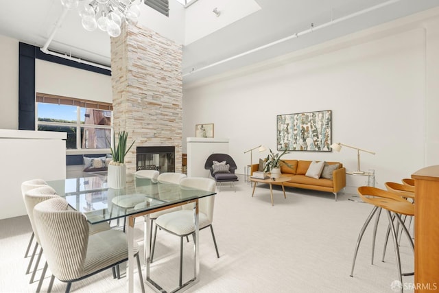 carpeted dining space with an inviting chandelier, a high ceiling, and a multi sided fireplace