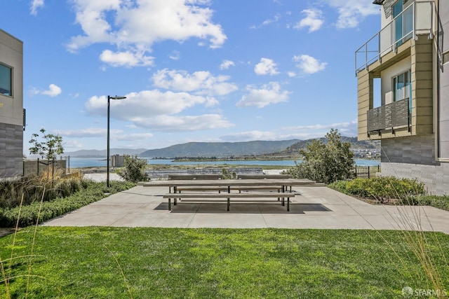 view of community with a water and mountain view and a yard