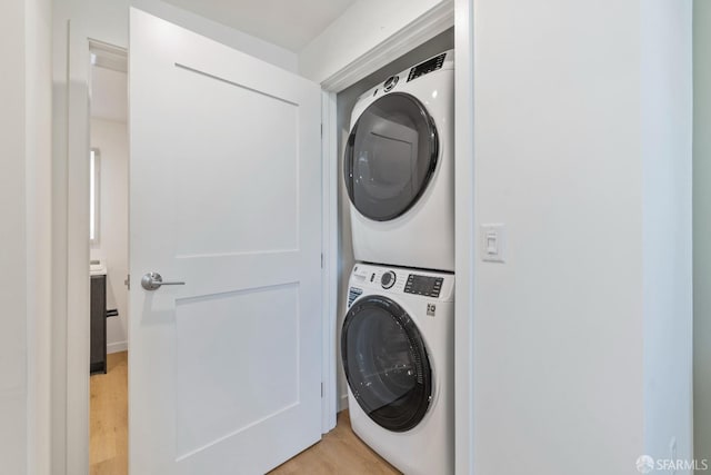 washroom featuring light hardwood / wood-style floors and stacked washer and clothes dryer