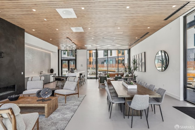 dining space with a wall of windows and wood ceiling