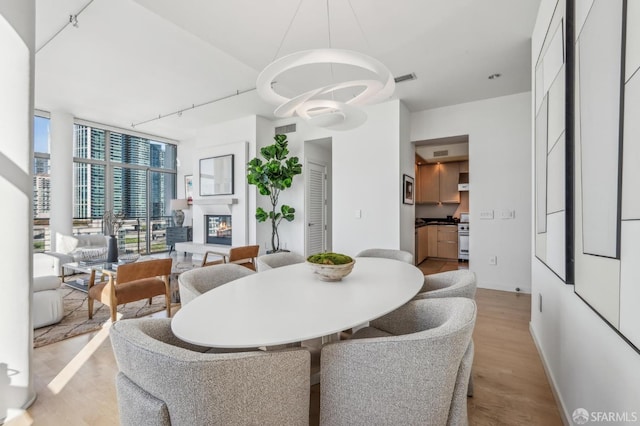 dining space with light wood-type flooring and expansive windows