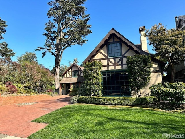 english style home with a front yard