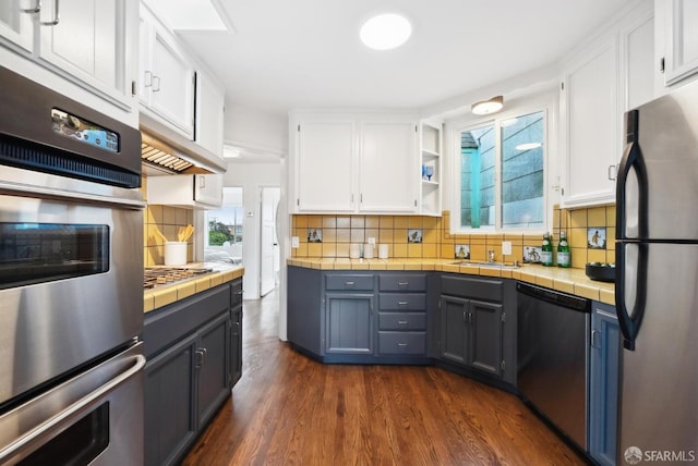 kitchen featuring tile countertops, white cabinets, and stainless steel appliances