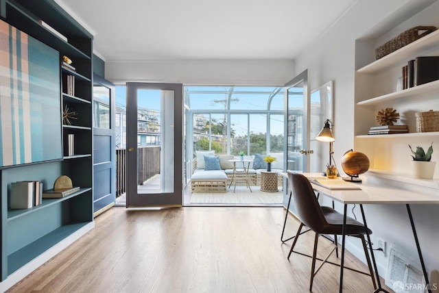 office area with wood finished floors, visible vents, and a sunroom