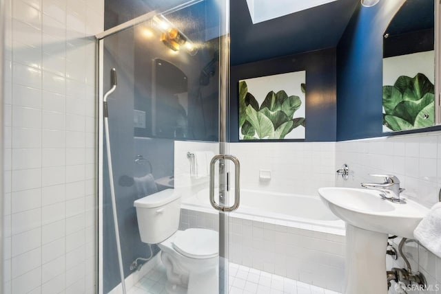 full bathroom featuring tiled bath, toilet, tiled shower, tile patterned floors, and tile walls