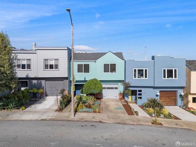 multi unit property featuring a garage, driveway, and stucco siding