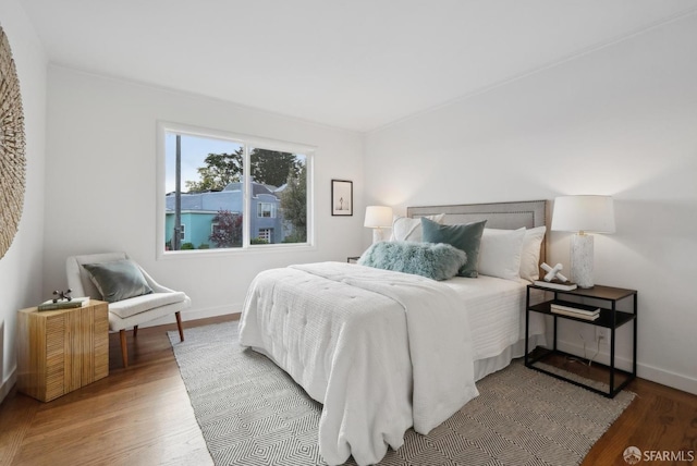 bedroom with baseboards and wood finished floors