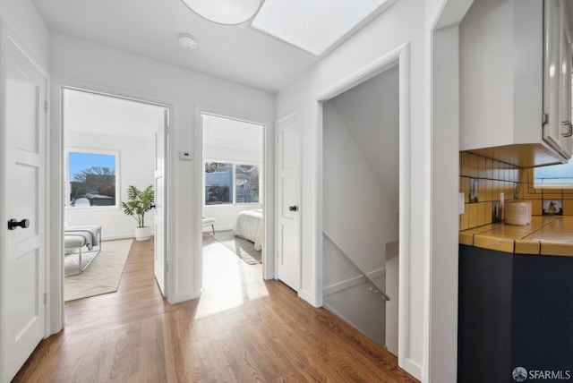 hallway with light wood-style flooring and baseboards