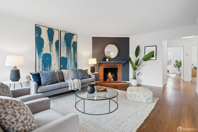 living room with a fireplace, wood finished floors, baseboards, and ornamental molding