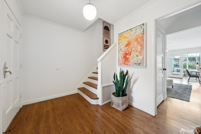 stairs featuring crown molding, baseboards, and wood finished floors