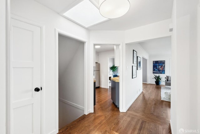 hallway with dark wood-type flooring and baseboards