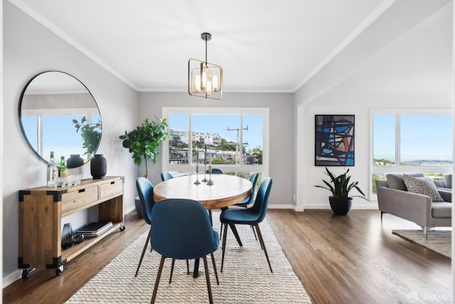 dining room featuring baseboards, an inviting chandelier, wood finished floors, and crown molding