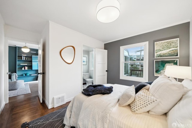 bedroom with dark wood-style floors, visible vents, crown molding, and baseboards