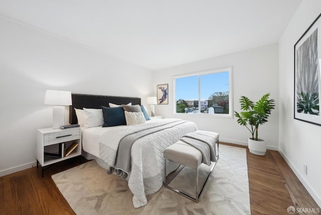 bedroom featuring wood finished floors and baseboards