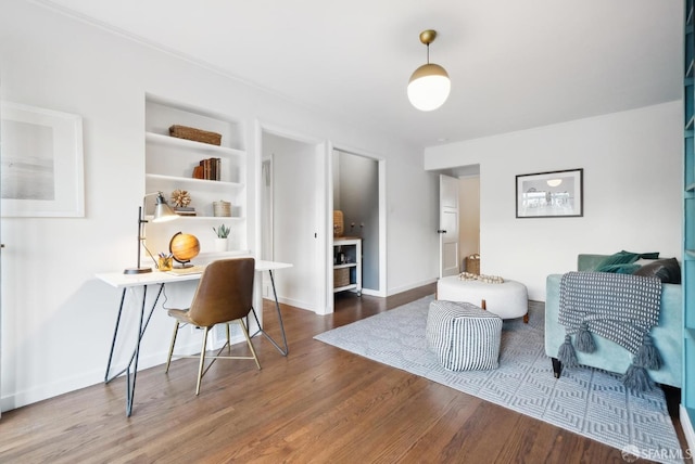 office space featuring built in shelves, wood finished floors, and baseboards