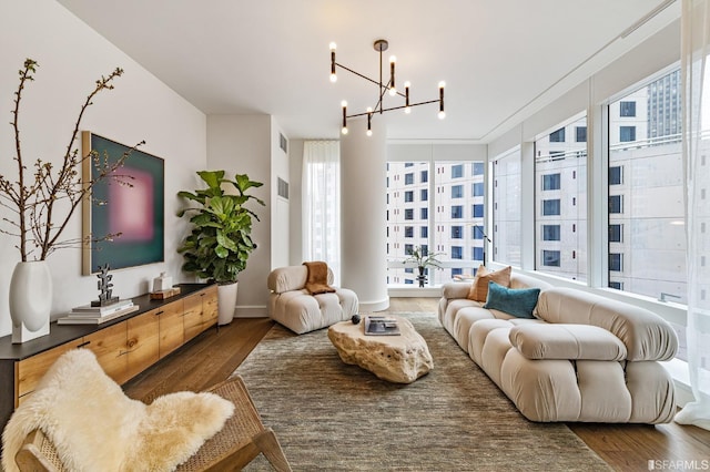 living room featuring a notable chandelier, wood finished floors, and visible vents