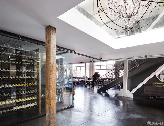 wine cellar featuring a notable chandelier, finished concrete floors, and expansive windows