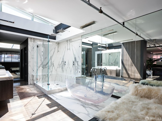 interior space with a marble finish shower and a soaking tub