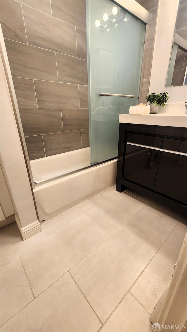 bathroom featuring tile patterned flooring, vanity, and combined bath / shower with glass door