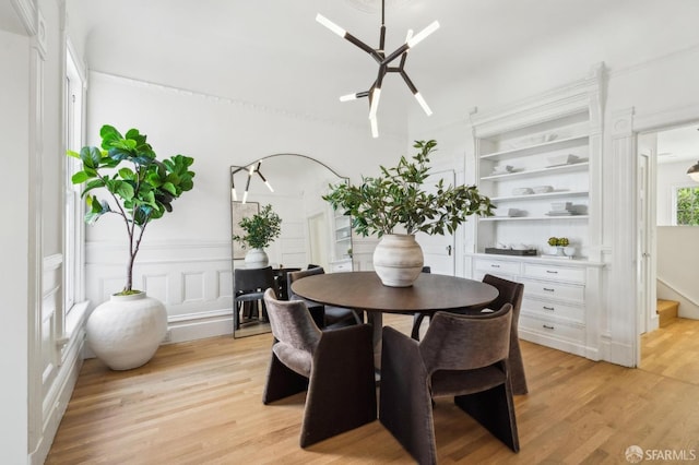 dining room featuring light wood-style flooring and built in shelves