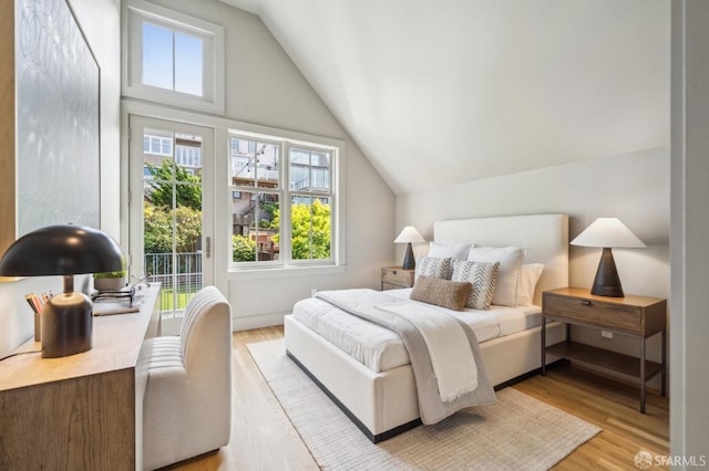 bedroom featuring vaulted ceiling, access to exterior, and light wood finished floors