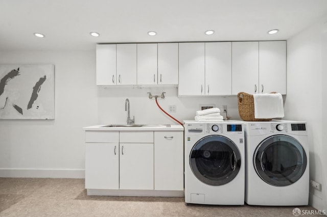 laundry room featuring cabinet space, recessed lighting, washing machine and dryer, and a sink